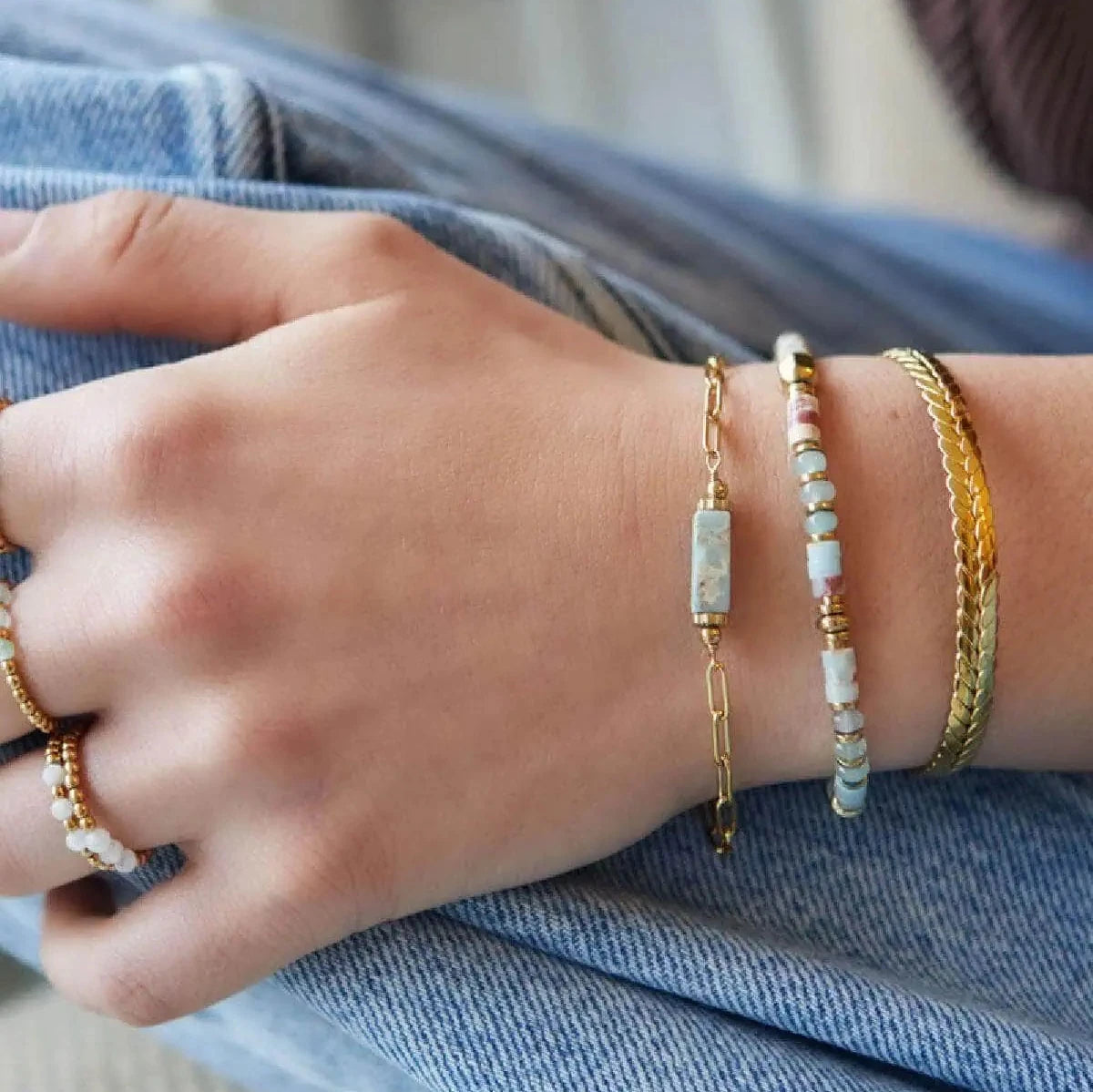 elastische armband met goudkleurige kralen en witte hematiet stenen