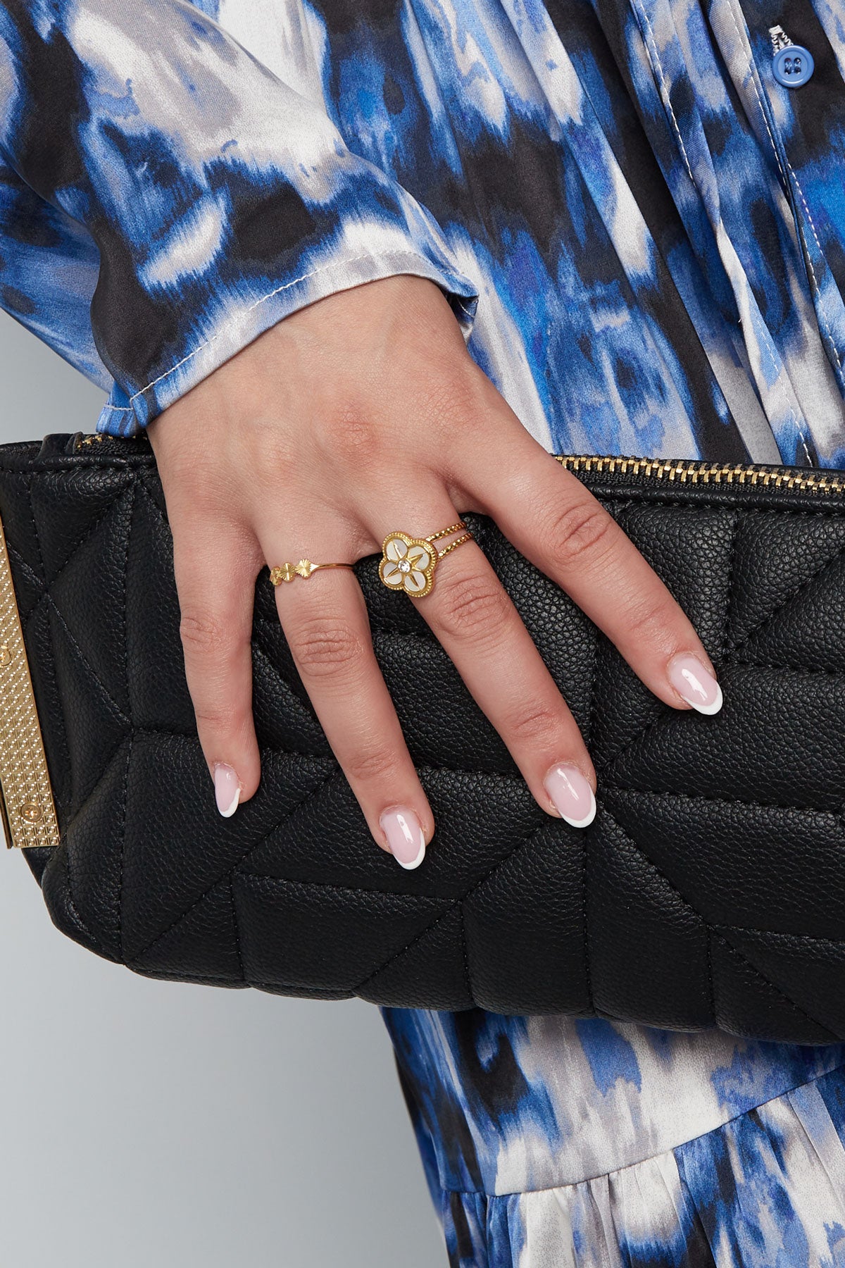Model met goudkleurige roestvrijstalen ring met drie bloemen