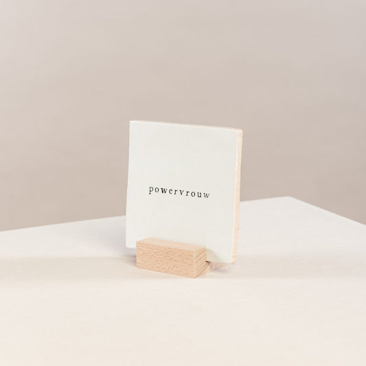 wit tegeltje in houten houder zodat de tegel rechtop staat