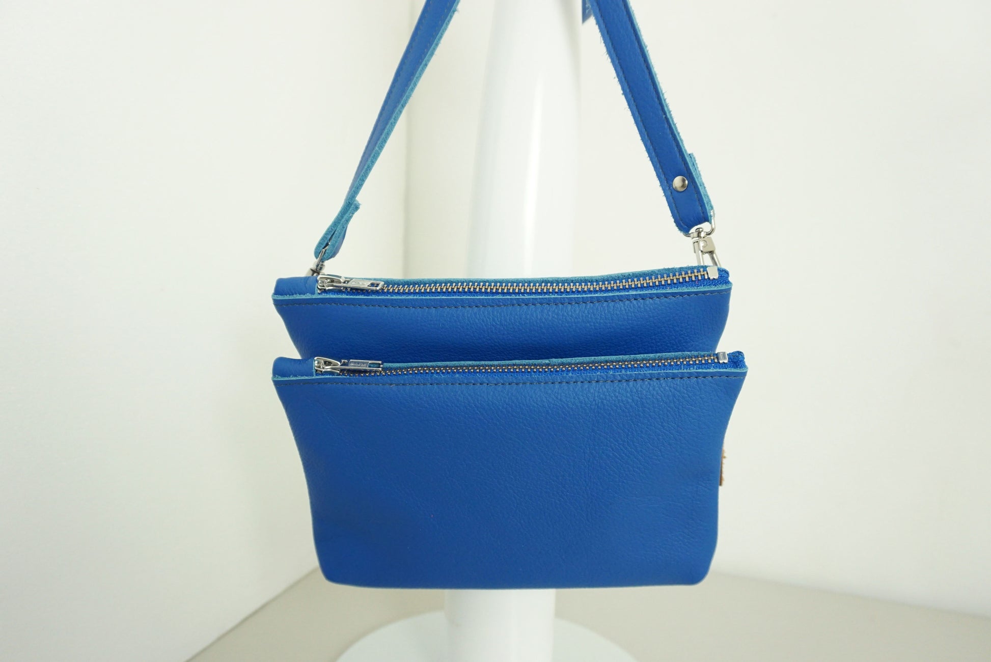 Kobaltblauwe Schoudertas van twee vakken die met drukknopen vast zitten met rits van gerecycled leer