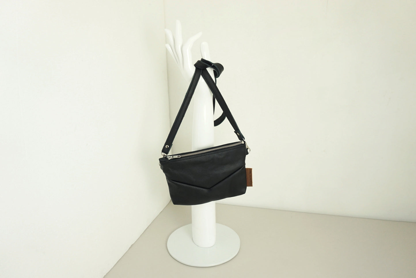 Handtas van gerecycled zwart leer met rits en v-stiksels en schouderband