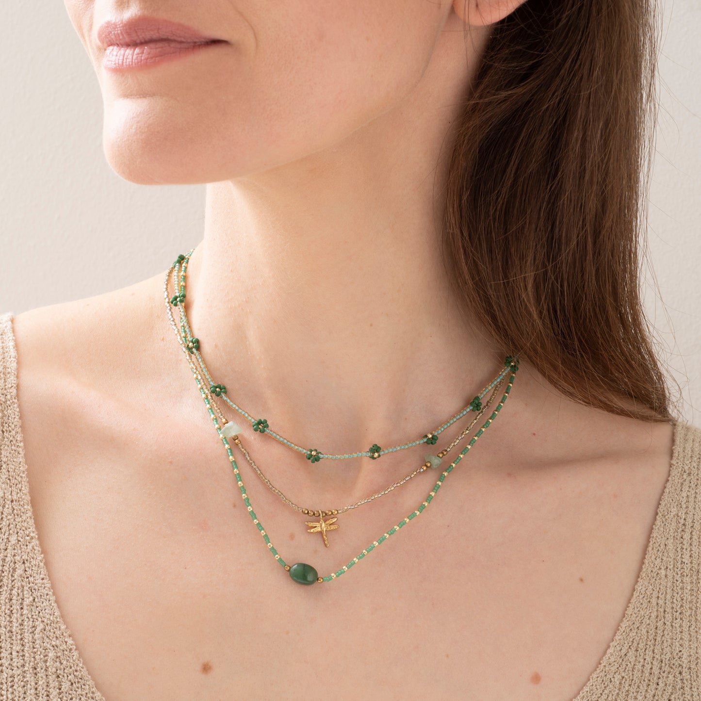 Modelfoto van Ketting confident van het merk A Beautiful Story met groene en gouden glaskralen en in het midden een aventurijn edelsteen. Samen met de Flowerfield en wildflower ketting.