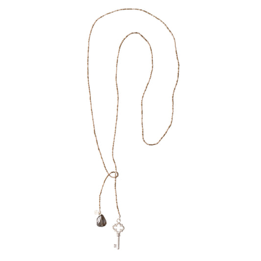 Ketting met grijze kralen en een bedel van een sleutel aan de ene kant en een bedel van een rookkwarts aan de andere kant. Geen sluiting, de uiteinde sla je over elkaar.