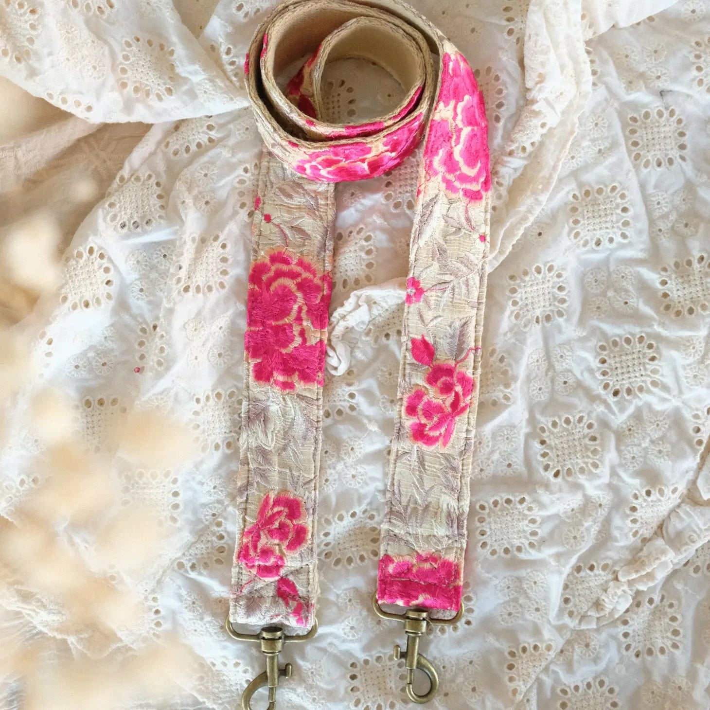 telefoon/tasriem gemaakt van handgeborduurde witte en fushia bloemen op witte stof