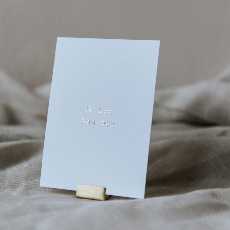 Klein kaartje met gouden letters 'Ik hou van ons' met gouden houder