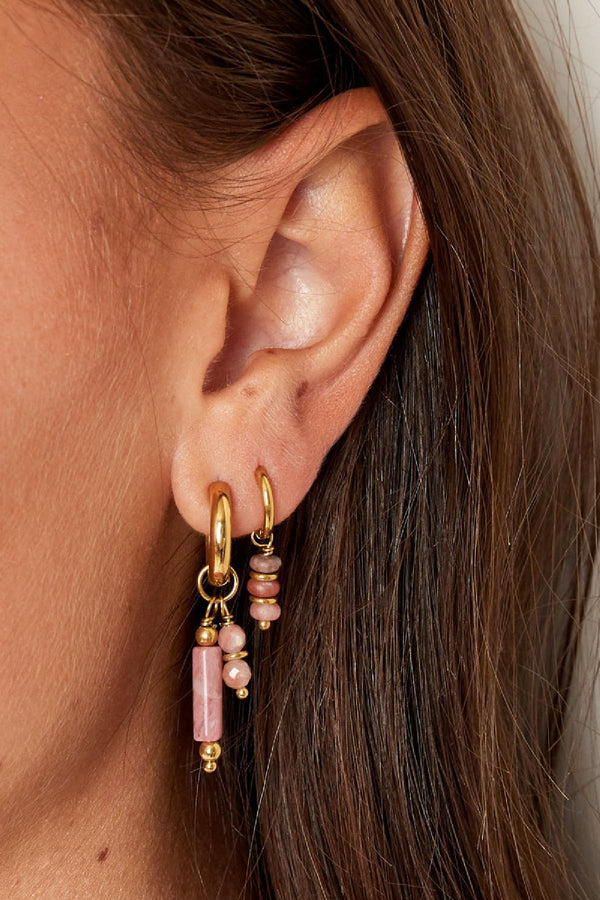 Model met oorbellen met drie roze steentjes