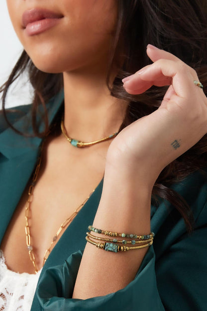 Model met elastische armbanden van goudkleurige en groene kralen