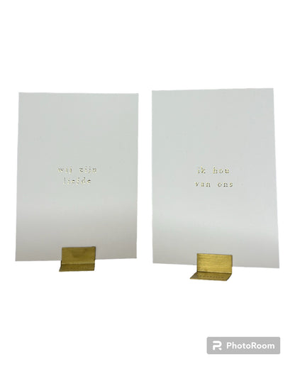 Klein kaartje met gouden letters 'Ik hou van ons' en 'wij zijn liefde ' met gouden houder