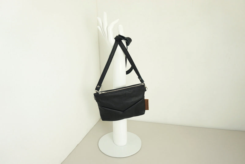 Handtas van gerecycled zwart leer met rits en v-stiksels en schouderband
