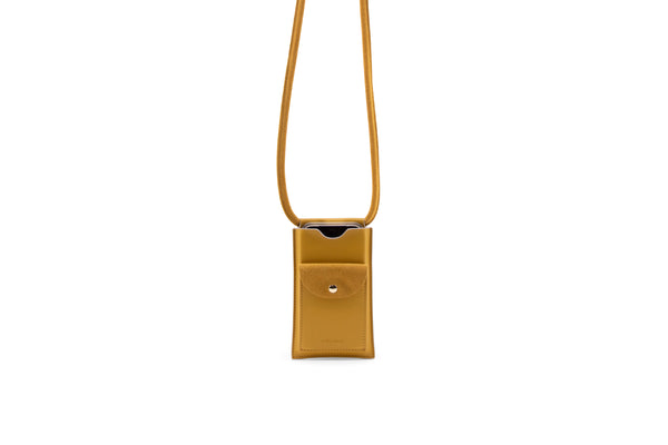Telefoontas in goudgele kleur van Vegan leather. De tas heeft op de voorkant een met drukknoop afsluitbaar vakje van suede.