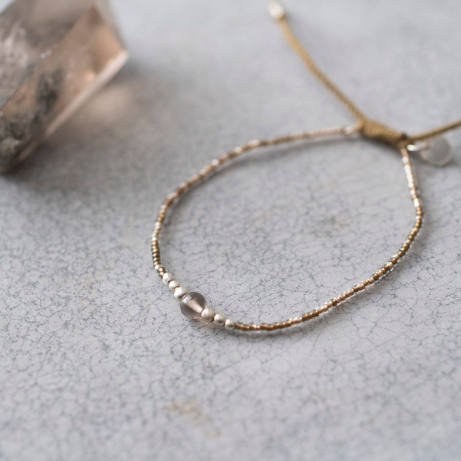 Grijze armband van A Beautiful story met zilveren en grijzen glaskralen en in het midden een rookkwarts edelsteen
