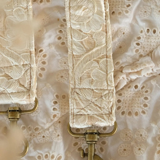 close up van handgemaakte telefoon/tasriem met grote witte geborduurde bloemen