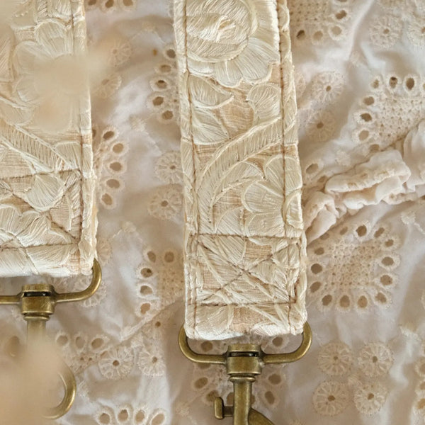 close up van handgemaakte telefoon/tasriem met grote witte geborduurde bloemen